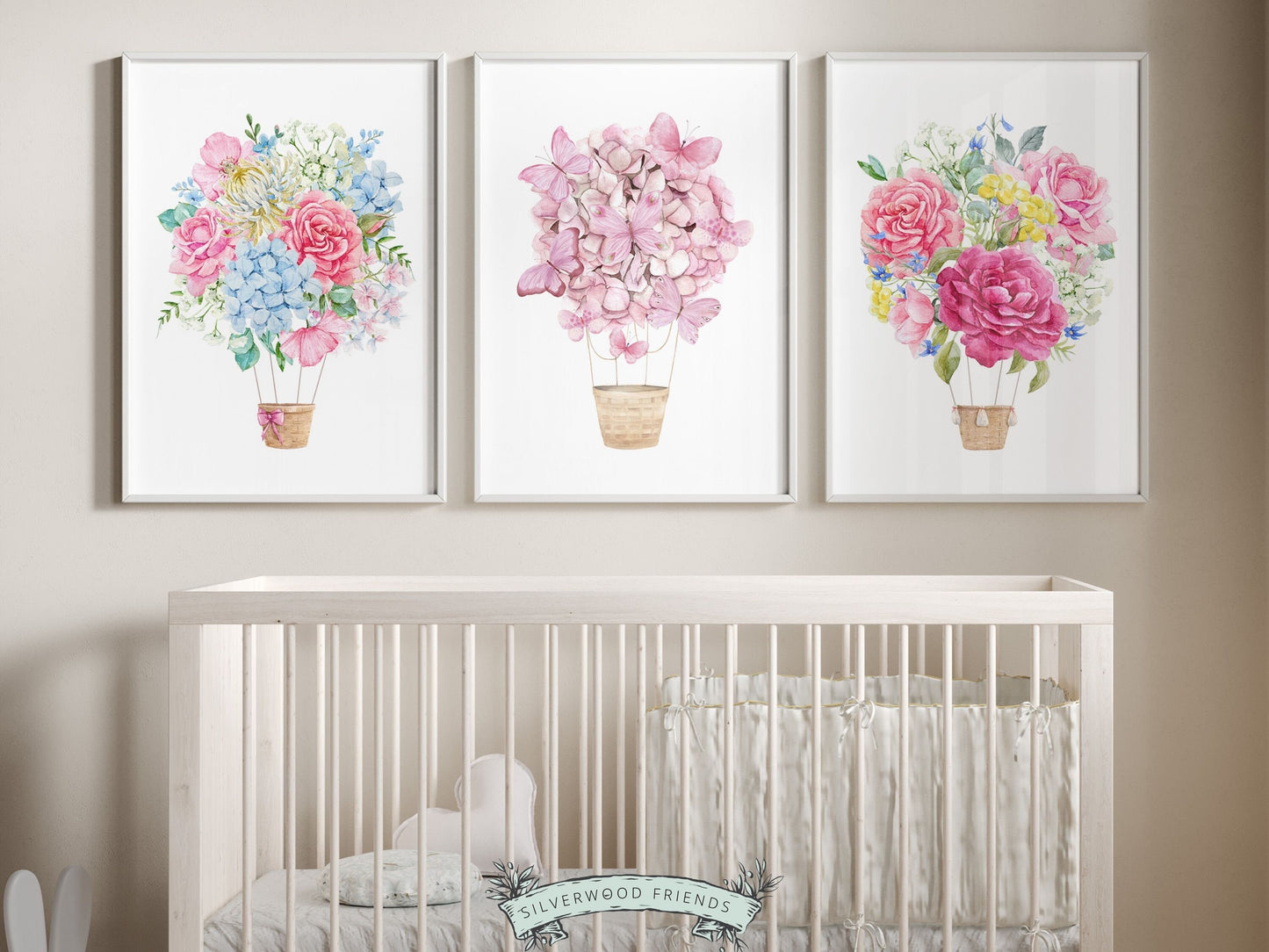 Set of 3 watercolor Hot Air Balloon Prints featuring delightful pink and blue wildflower adorned balloons. A charming addition to your nursery decor and also as an adorable baby shower gift, these prints infuse sweetness and elegance into any space.