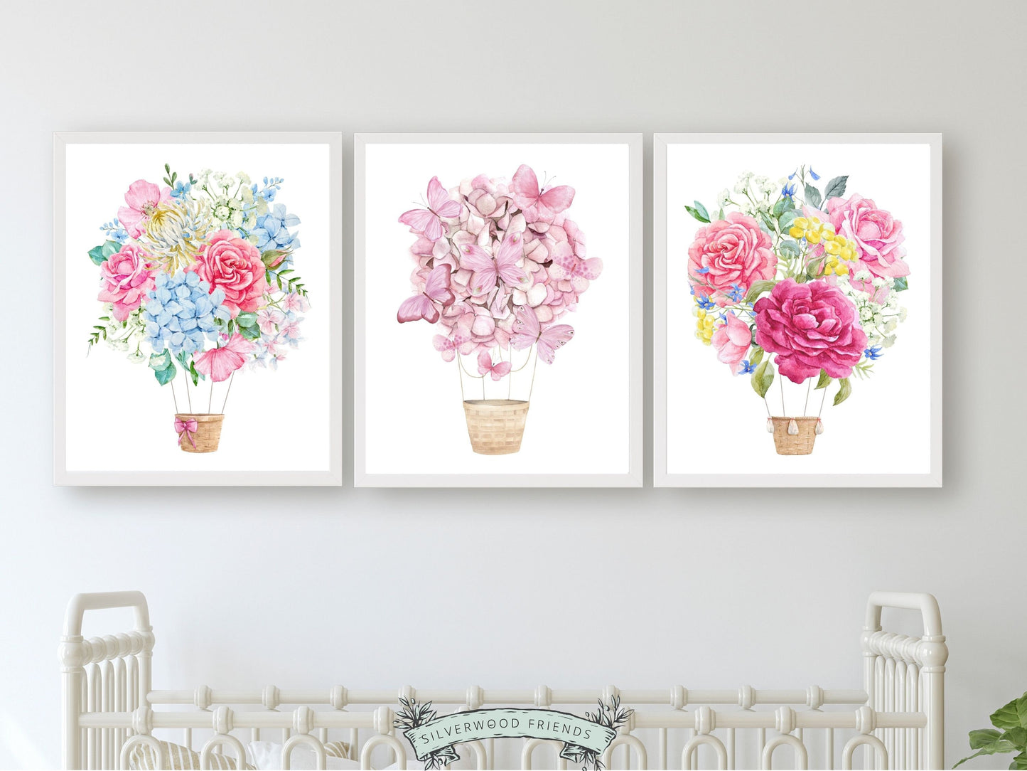 Set of 3 watercolour Hot Air Balloon Prints, featuring delightful pink and blue wildflower adorned balloons. A charming addition to your nursery decor and also makes an adorable baby shower gift, these prints infuse sweetness and elegance into any space.