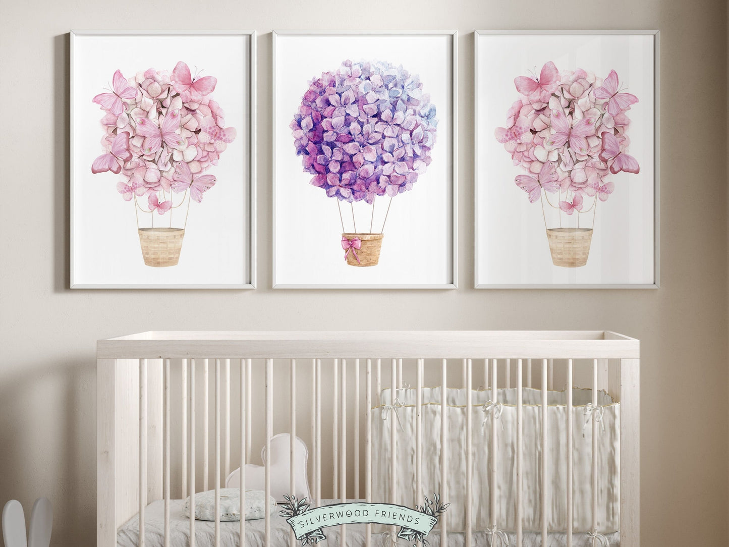 Set of 3 Watercolor Hot Air Balloon Prints, perfect for adding a whimsical touch to trendy dorm rooms or teen girls bedrooms with their delightful pink and purple wildflower adorned balloons. Perfect for your nursery decor or as a baby shower gift.