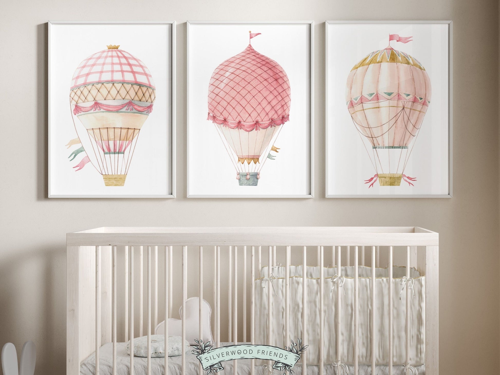 Set of 3 watercolor pink Hot Air Balloon Prints. Whether adorning a nursery or adding a pop of color to a dorm room, these vibrant prints are as playful as they are versatile. Perfect for your nursery decor and as a baby shower gift.