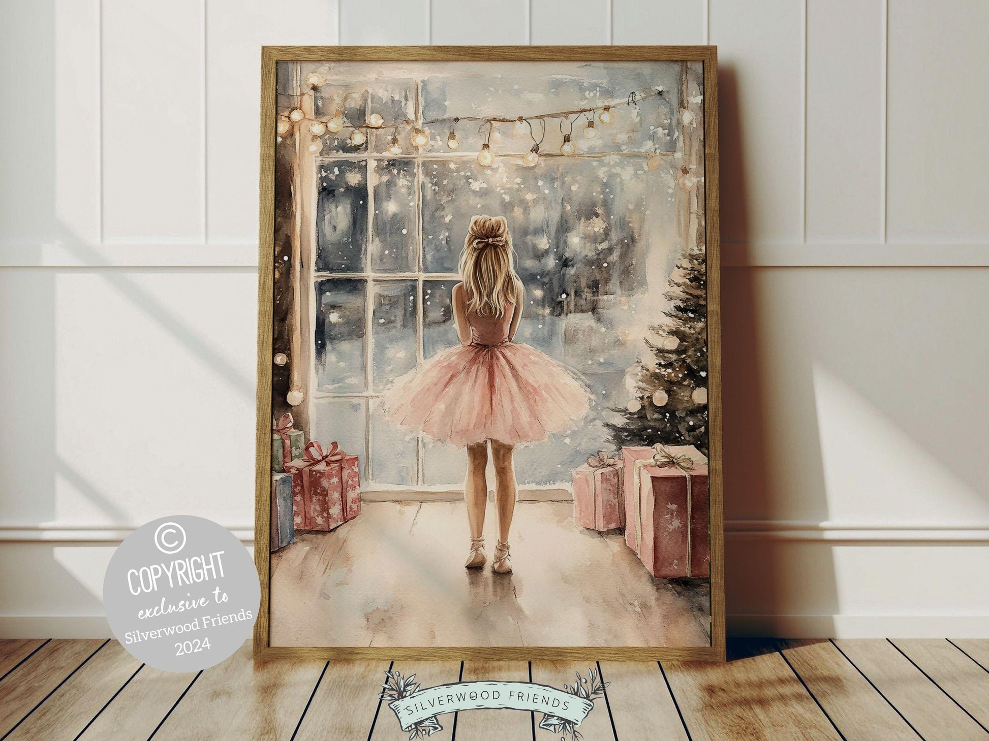 Whimsical ballerina Christmas print showcases a sweet little ballerina in a pale pink tutu, standing under twinkling fairy lights by a Christmas tree and gazing at the falling snow. The perfect gift for a young ballet lover or a babys first Christmas