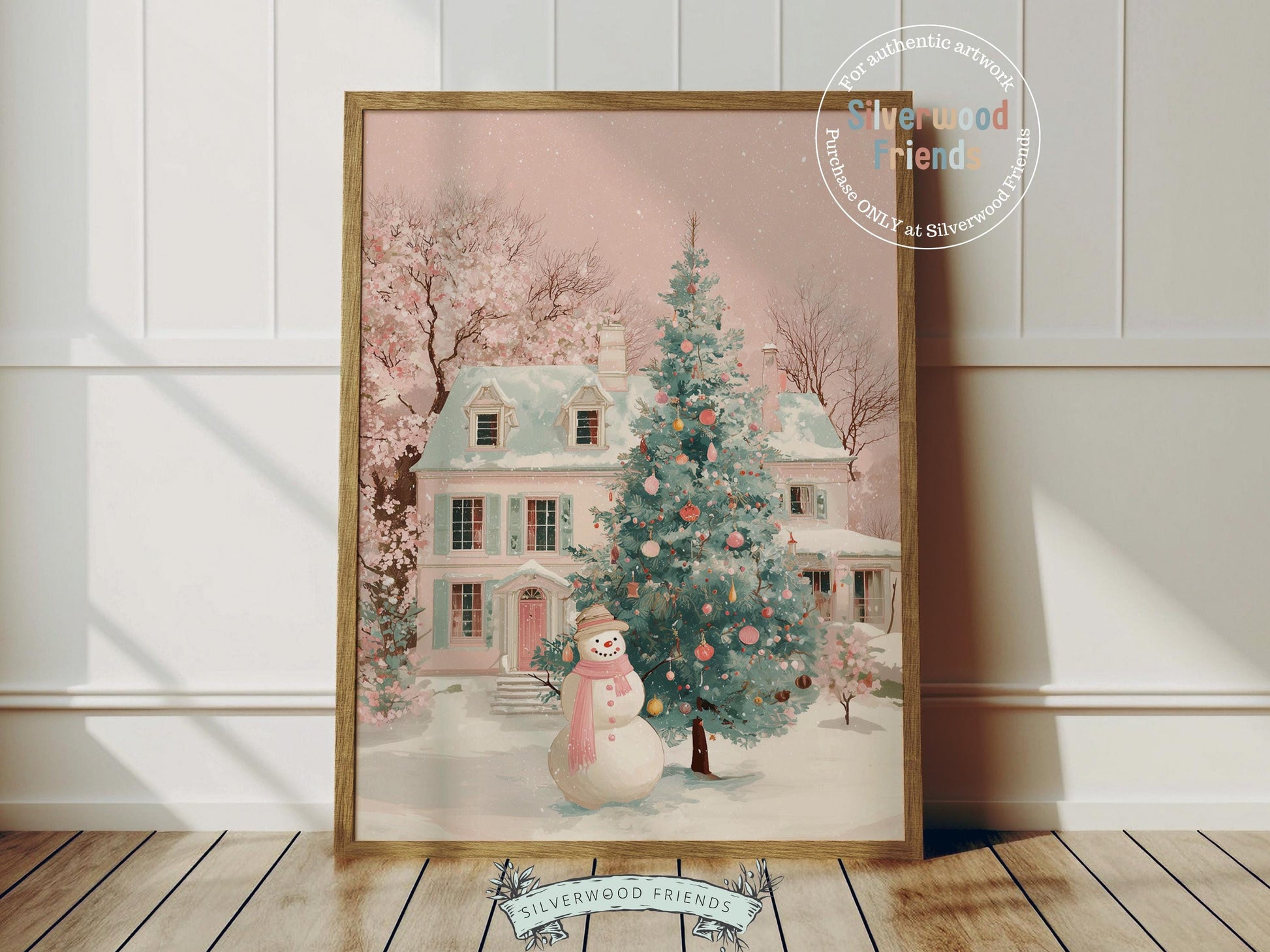 This delightful Christmas print features a cheerful snowman in a soft pink scarf standing before a pastel pink and green village house dusted with snow. With its gentle watercolor tones and whimsical charm, it brings a cozy, festive touch to any nursery or holiday home décor.