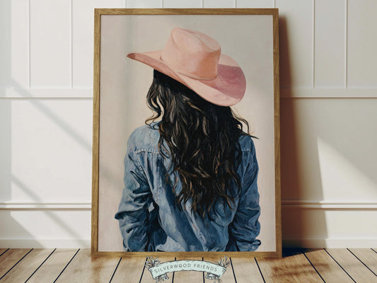 Create a calm and beautiful space with this western cowgirl wall art print, featuring a softly styled portrait of a cowgirl in a pink cowgirl hat, illustrated in a dreamy oil painting style with visible brushstroke texture and warm, rustic tones. This timeless artwork has a rich, canvas-like finish that adds depth, softness, and a charming farmhouse feel to any room.