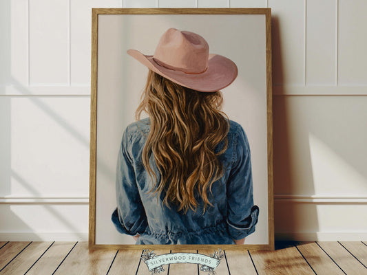 Create a calm and beautiful space with this western cowgirl wall art print, featuring a softly styled portrait of a brunette cowgirl in a pink cowgirl hat, illustrated in a dreamy oil painting style with visible brushstroke texture and warm, rustic tones. This timeless artwork has a rich, canvas-like finish that adds depth, softness, and a charming farmhouse feel to any room.