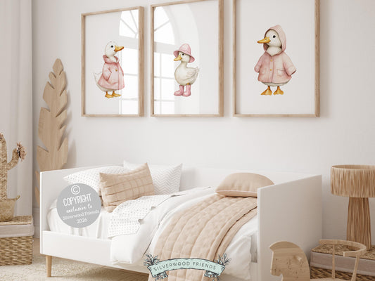 Create a warm and whimsical space with this pink duck nursery wall art set, featuring adorable watercolor ducks and ducklings dressed in pale pink raincoats and boots for a sweet, storybook feel. Designed in soft pastel tones with a cozy farmhouse charm, this farm animal wall art set adds personality and warmth to any nursery, mudroom, or kids room, making it a timeless and versatile decor piece.