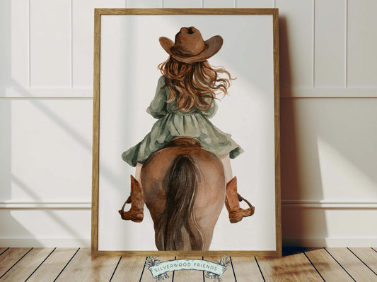 Create a calm and storybook-inspired space with this western cowgirl riding horse nursery wall art print, featuring a beautifully illustrated young cowgirl in a flowing sage green dress and cowboy hat riding her brown horse, captured from behind in a soft watercolor style.