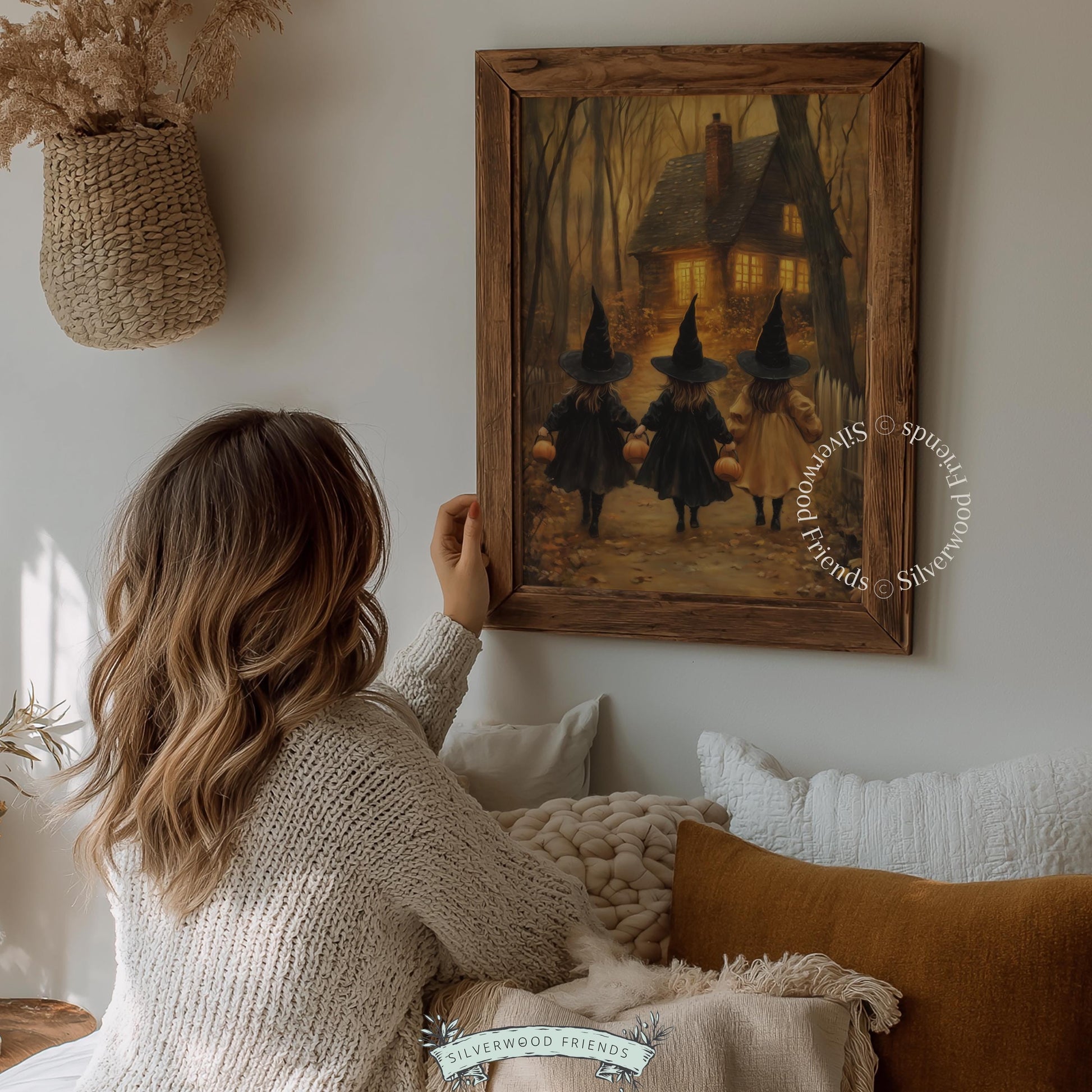 Cottagecore trick-or-treat wall art digital download — moody autumn scene with three girls in witch attire and glowing woodland cottage backdrop